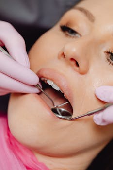 Dental checkup with tools in a patient's mouth for hygiene procedure.